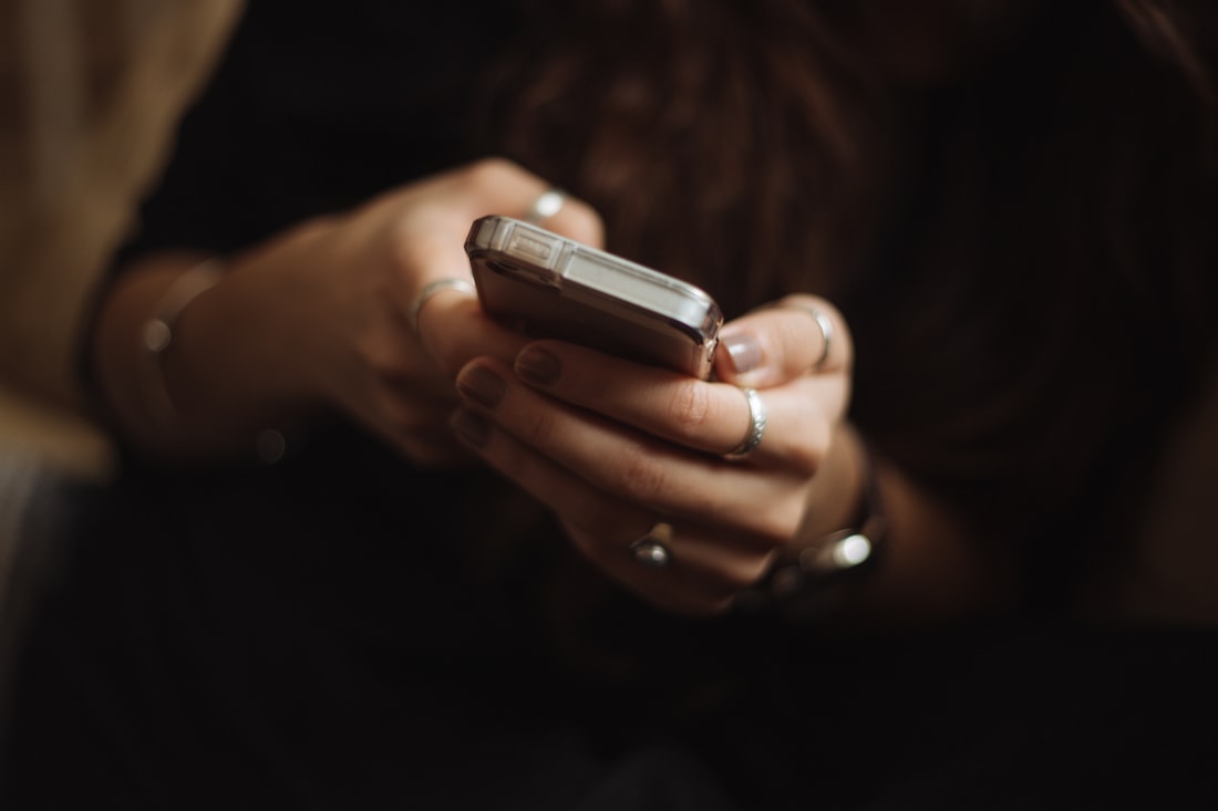 Pengguna menatap layar ponsel sambil bersantai